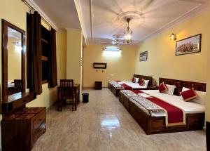 a hotel room with two beds and a table at Beena Homestay in Jaipur