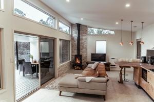 a living room with a couch and a table at Bruny Island Oceanfront Luxe Cabin with Spa in Adventure Bay
