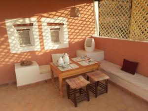 una pequeña sala de estar con mesa y sofá en chambre d'hôte yamina en Tafraoute