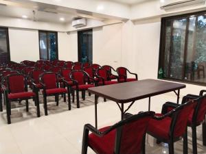 a conference room with tables and chairs and windows at Cocorico Beach Resort in Dapoli