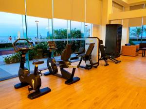 a gym with treadmills and exercise equipment in a building at Relaxing Stay with Sea View at Arterra in Mactan