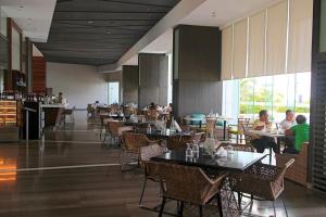 a restaurant with tables and people sitting at tables at Relaxing Stay with Sea View at Arterra in Mactan