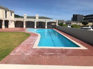 a swimming pool in front of a building at Big Bay Beach Club 134 in Bloubergstrand