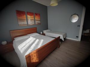 a bedroom with two beds and two paintings on the wall at Dianostellamarina in Diano Marina