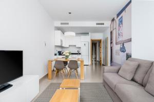 ein Wohnzimmer mit einem Sofa und einem Tisch in der Unterkunft Suites Del Pintor in Málaga