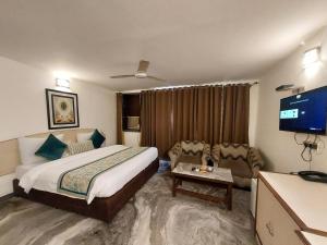 ニューデリーにあるHotel Green Castle (Heritage Hotel)のベッドとテレビがあるホテルの部屋