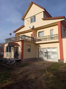 a large house with a balcony on top of it at Khutorok Svergio in Chesnovka