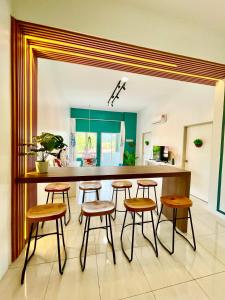 a kitchen with wooden stools and a counter in a room at The Cube Langkawi in Kuah