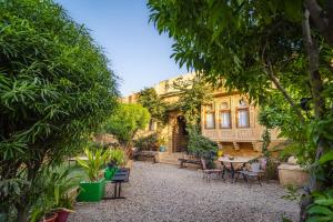 a courtyard of a house with trees and chairs at Moustache Jaisalmer in Jaisalmer