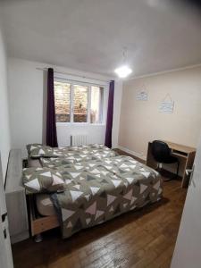 1 dormitorio con cama, escritorio y ventana en Herve patrick, en Saint-Brieuc