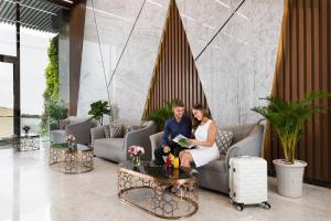 a bride and groom sitting on a couch in a lobby at Emerald Bay Hotel & Spa in Nha Trang