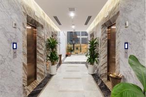 un couloir avec des plantes en pot dans un bâtiment dans l'établissement Emerald Bay Hotel & Spa, à Nha Trang
