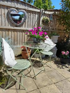 a table and chairs with flowers on a patio at Debonair bnb @33 in Bromsgrove