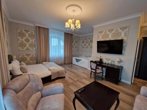 a living room with a couch and a tv at Pałacyk Zawady in Kowiesy