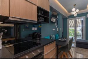 a kitchen with blue walls and a black counter top at Artistic apt in vibrant Gazi with large terrace by GHH in Athens