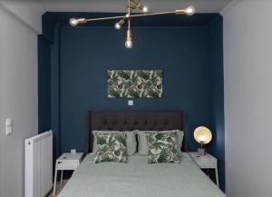 um quarto com paredes azuis e uma cama com almofadas em Artistic apt in vibrant Gazi with large terrace by GHH em Atenas