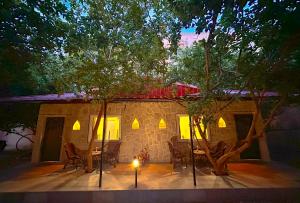 a house with a table and chairs in front of it at Ranthambhore National Resort in Sawāi Mādhopur