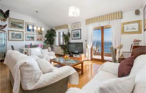 a living room with white couches and a television at Awesome Apartment In Icici With House Sea View in Ičići