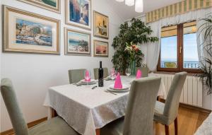 a dining room with a table with pink hats on it at Awesome Apartment In Icici With House Sea View in Ičići