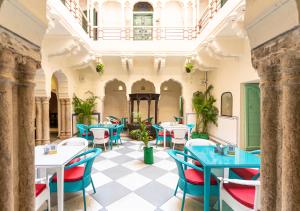 a restaurant with blue tables and chairs in a building at Bloom Boutique - Chelon Haveli in Jaipur