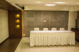 Hotel Corporate في نافي مومباي: قاعة اجتماعات مع طاولة وكراسي