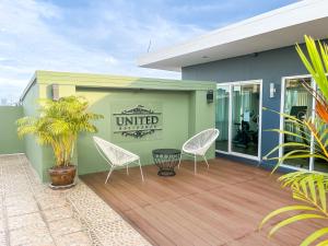 a patio with two chairs and a sign that reads united at United Residence Ekamai Bangkok in Bangkok