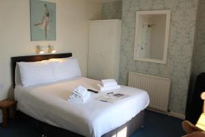 een hotelkamer met een groot bed met handdoeken erop bij The Redcliff in Weymouth