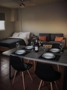 a table with plates and wine glasses on it in a living room at Upon Volos - modern studio with panoramic view in Volos