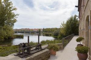 a view of a river with a bridge in the background at Hospedium Hotel Casino Del Tormes in Salamanca