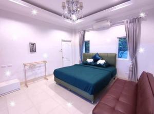 een slaapkamer met een blauw bed en een bank bij Sun Poolvilla Bangsaray in Bang Sare +25 foto's