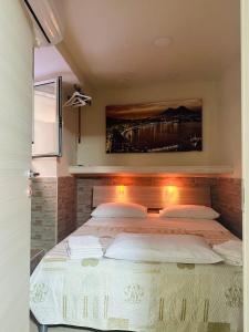 ナポリにあるHome Pulcinella Napoliのベッドルーム1室(壁に絵画が描かれた大型ベッド1台付)