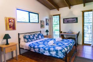 Schlafzimmer mit einem Bett, einem Schreibtisch und Fenstern in der Unterkunft 1770 Southern Cross Travellers Retreat in Agnes Water