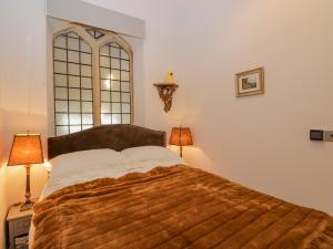 a bed in a bedroom with two lamps and a window at 1 Countess Chapel in Bath