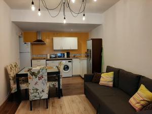 a living room with a couch and a table and a kitchen at Apartamentos Andrada in Casar de Cáceres