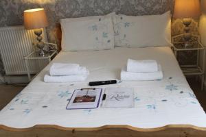 a bed with a white bedspread with a book and towels at The Redcliff in Weymouth