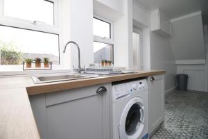 a kitchen with a washing machine and a sink at Wern farm cottage in Pontypool