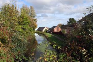 een rivier in een dorp met huizen en bomen bij Wern farm cottage in Pontypool