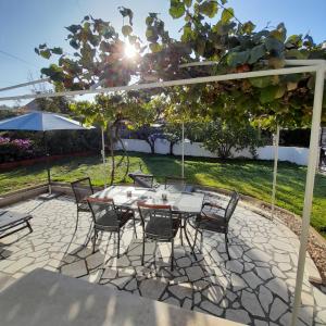 eine Terrasse mit einem Tisch und Stühlen unter einer Pergola in der Unterkunft Casa Letizia in Umag