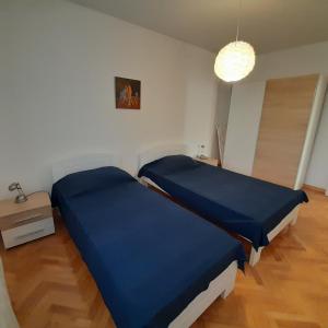 2 camas en una habitación con sábanas azules en Casa Letizia, en Umag