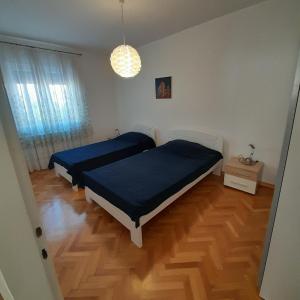 1 dormitorio con 2 camas y suelo de madera en Casa Letizia, en Umag