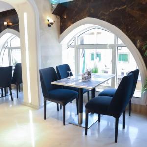 吉達的住宿－لابرادوريت，一间带桌子和蓝色椅子的用餐室