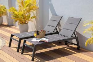 a black bench and a table and two chairs at Urbanite Hotel in Vientiane