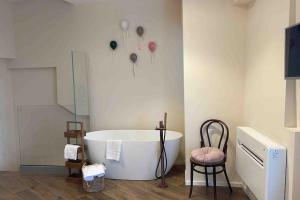 a bathroom with a bath tub and a chair at Dimora Estlevante in Vieste