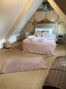 una camera da letto con letto e lenzuola e cuscini rosa di Manoir de Kerledan a Carhaix-Plouguer