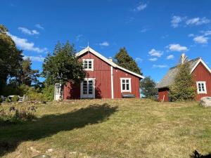 a red barn on top of a grass field at Södragården - traditionally Swedish in Annerstad