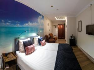 a bedroom with a large bed with a view of the ocean at Hotel de Zwaan in Schoondijke