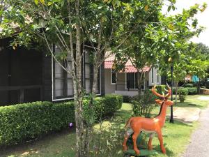 a statue of a deer standing next to a tree at Chanpraya Resort in Chanthaburi