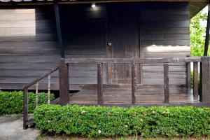 una veranda in legno di una casa con ringhiera in legno di Chanpraya Resort a Chanthaburi