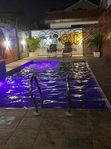 a swimming pool at night with lights in the water at The Cabyn in Accra