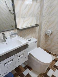 a bathroom with a toilet and a sink and a mirror at Speed 8 Inn Moalboal in Moalboal